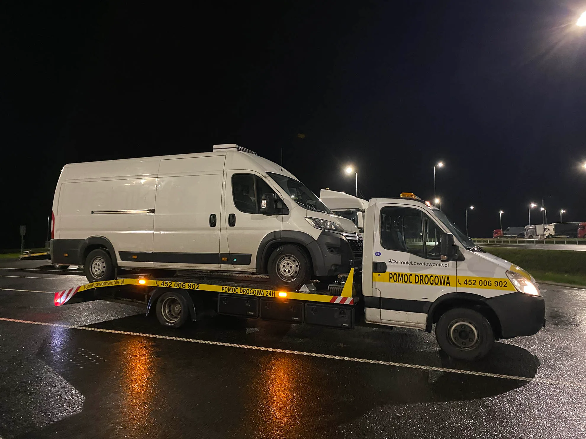 Pomoc drogowa Warszawa - kierowca zabezpiecza pojazd na lawecie